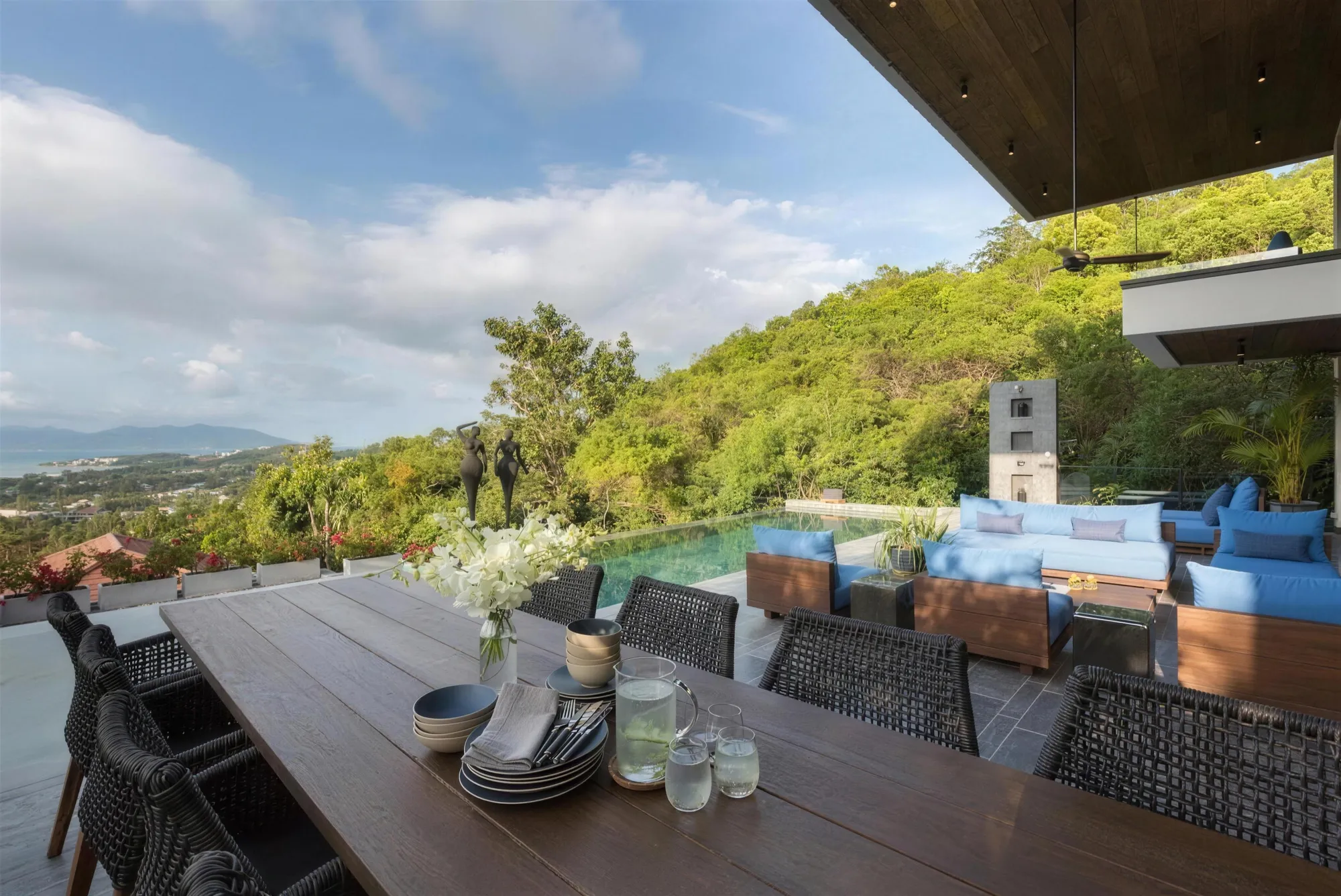 The pool terrace and long dining table in daylight